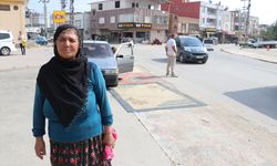 Adana'da tozdan rahatsız olan kadın yoldaki çukurları halıyla kapattı