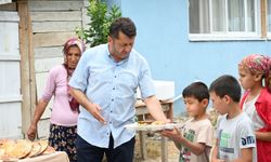 İmam taş fırında pişirdiği ekmekleri köylülere ikram ediyor